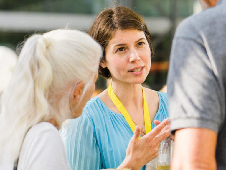 Vorstandssprecherin Aysel Osmanoglu im Gespräch mit zwei Personen.