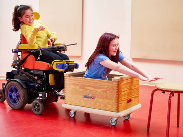 Das Bild zeigt zwei Schülerinnen der Freien Waldorfschule Wüfrath. Eine Schülerin sitzt im Rolltstuhl.