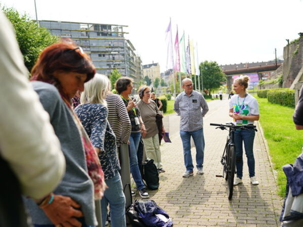 Menschen stehen bei einem Fahrradworkshop auf einem Vorplatz zusammen.