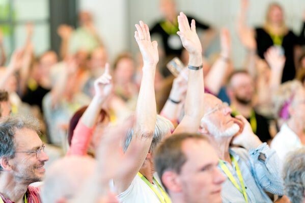 Menschen stimmen per Handzeichen ab.